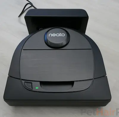 NEATO D6 robot vacuum on floor with charging base